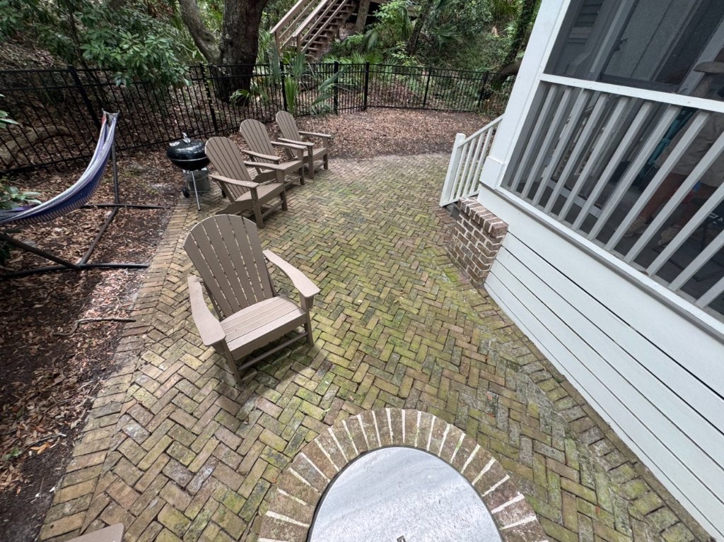 Patio with heavy moss and algae growth before Blueprint Construction soft wash restoration — Golden Isles, GA