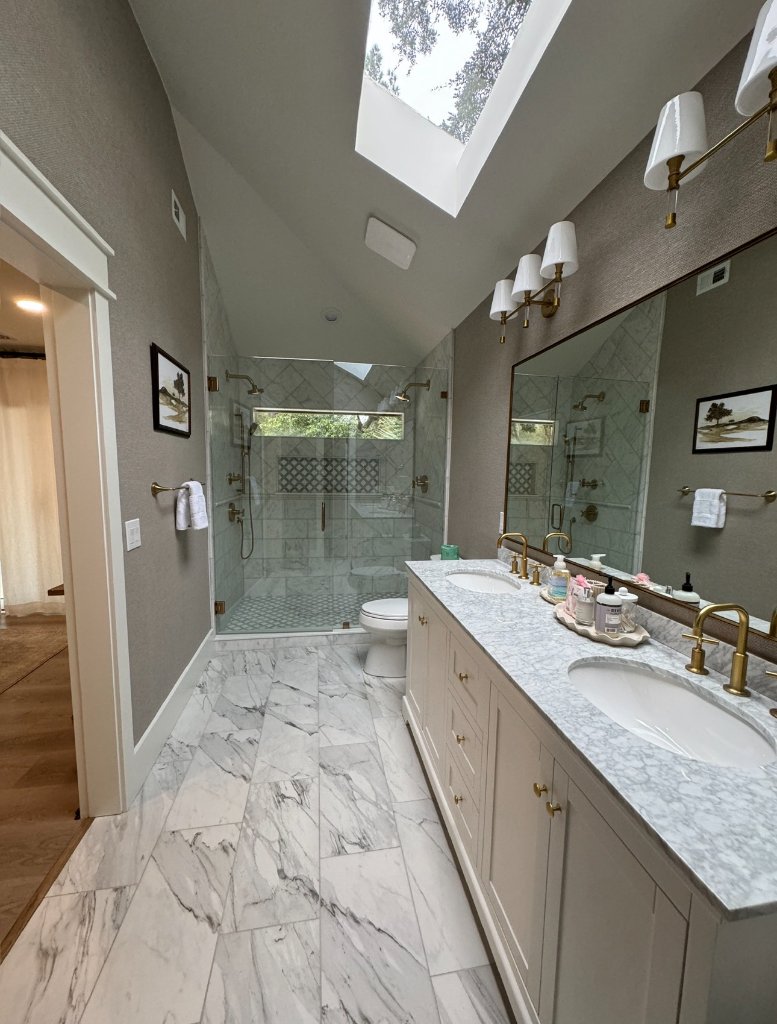 Primary bathroom with skylight and dual vanity - Blueprint Construction