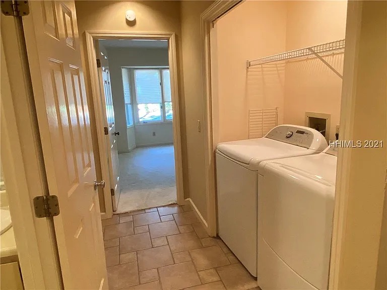 Dated laundry room with basic washer/dryer and worn tile flooring before Blueprint Construction renovation — Golden Isles, GA
