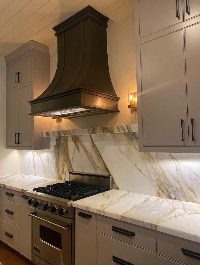 Luxury kitchen with black hood and marble backsplash - Blueprint Construction