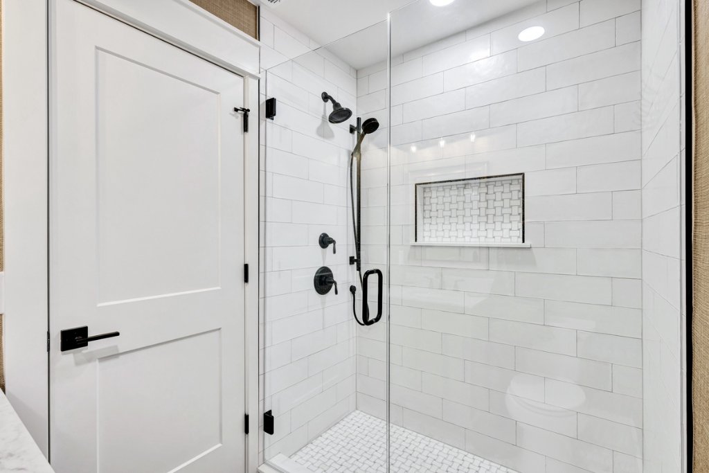 Luxury custom walk-in shower with subway tile, frameless glass enclosure, and matte black fixtures after Blueprint Construction bathroom remodel — St. Simons Island, GA