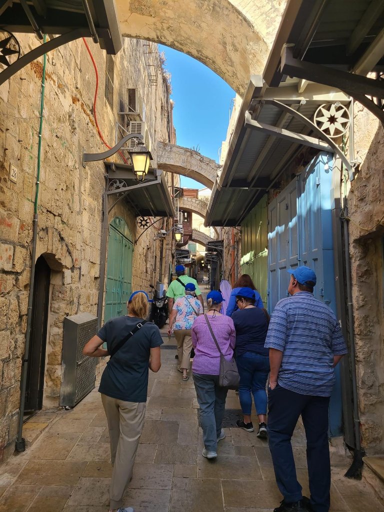 Pilgrims walking through the ancient Via Dolorosa in Jerusalem