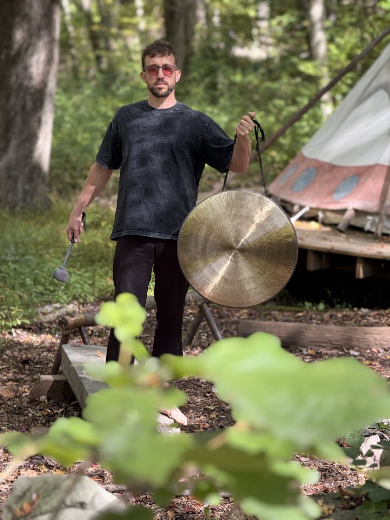 Maxwell Reichert with gong in nature