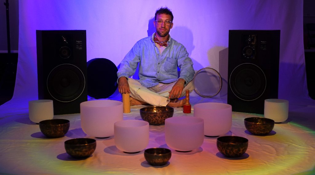 Maxwell with crystal and Himalayan singing bowls at Onda Healing Arts