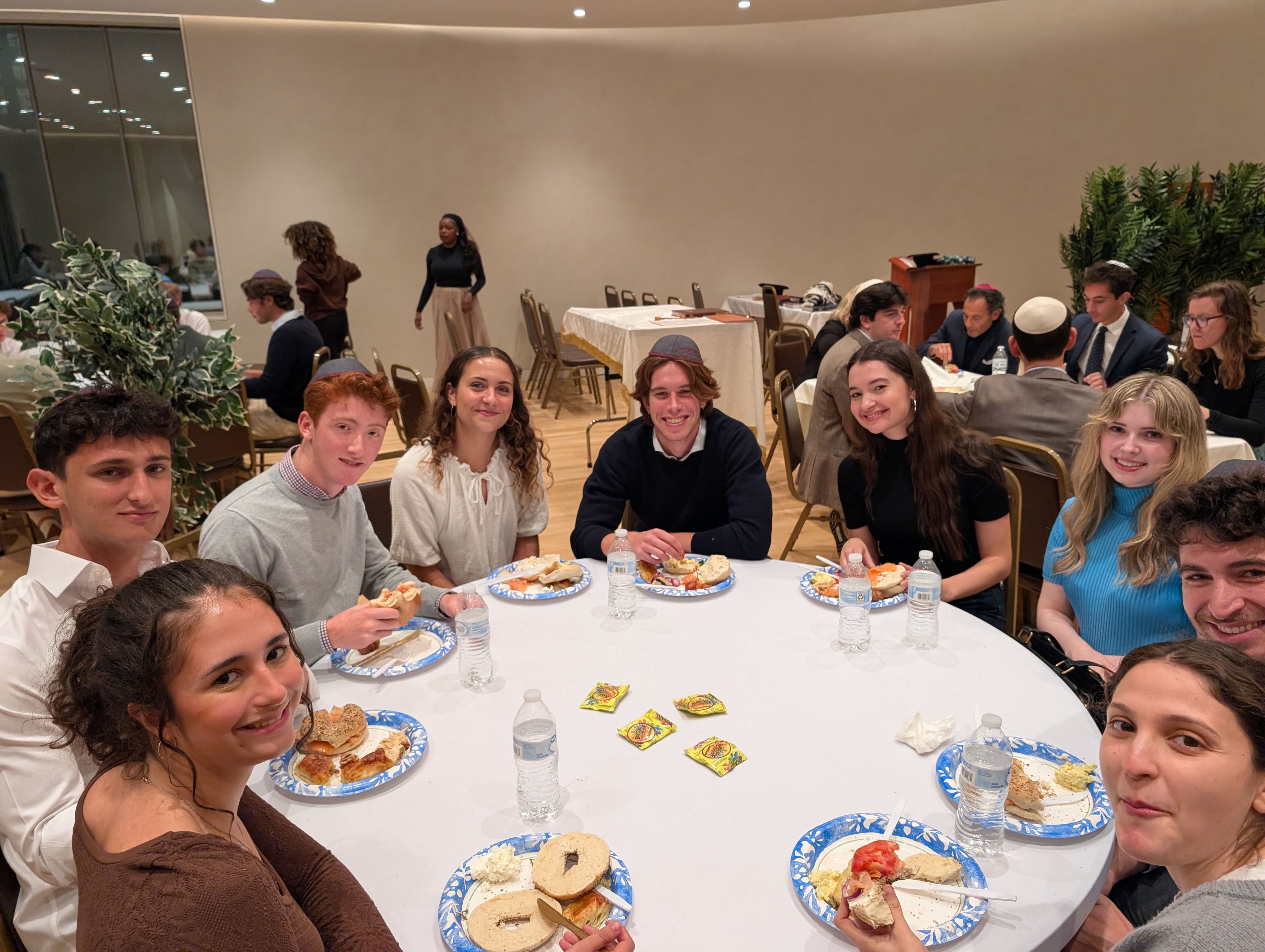 Family and students gathered around a Shabbat dinner table at Chabad House