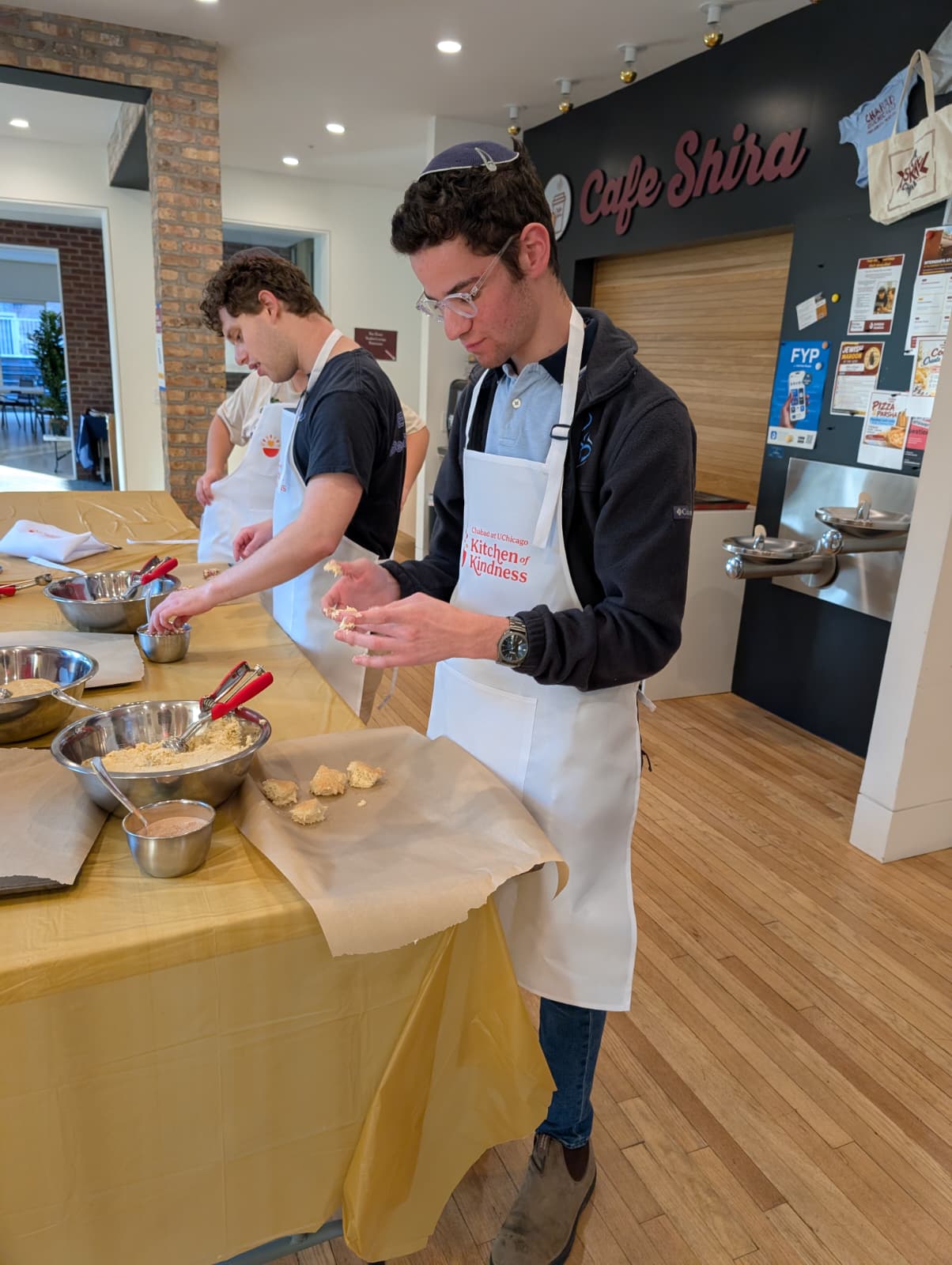Students scooping cookie dough during a Kitchen of Kindness cook night