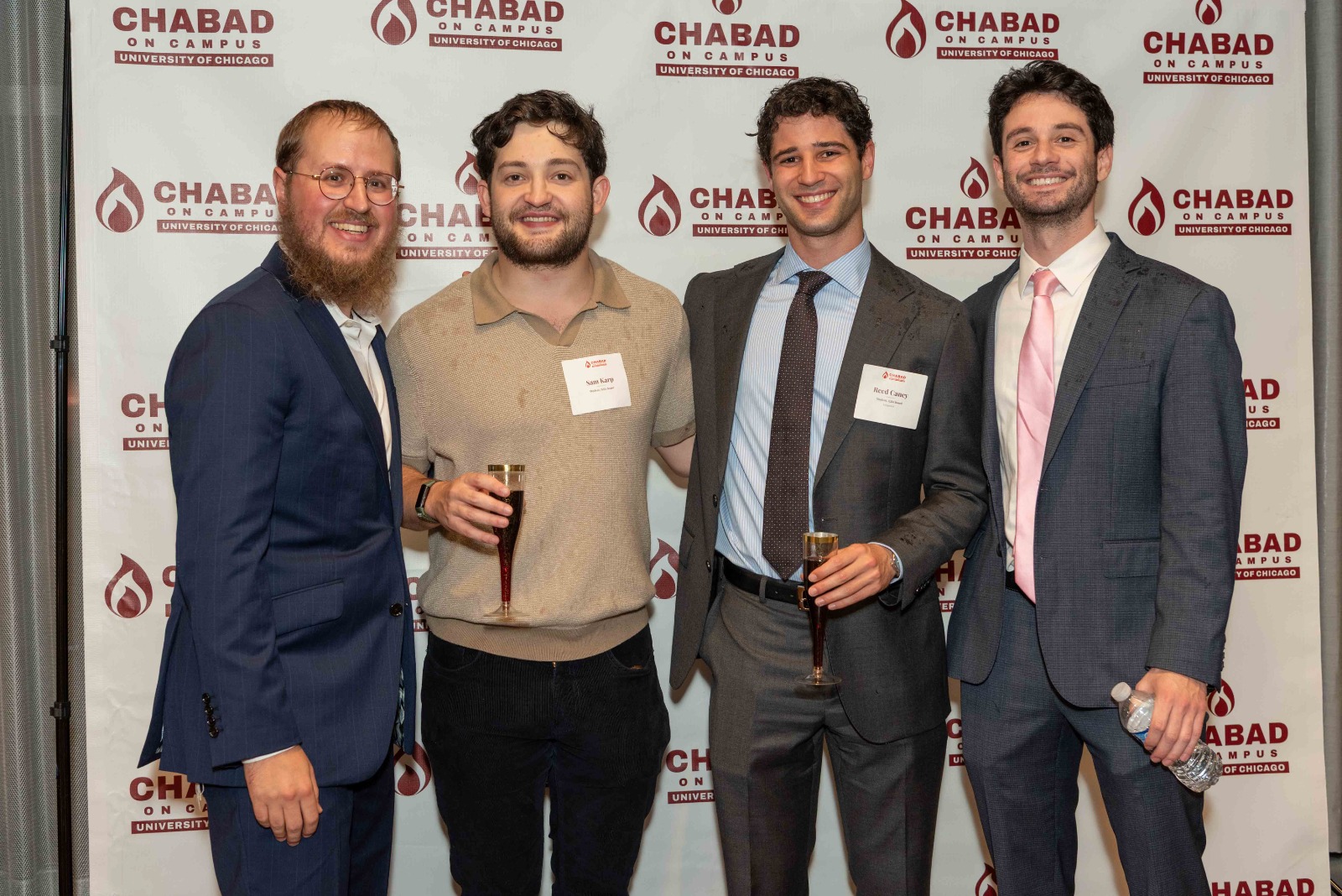 Attendees posing in front of the Chabad on Campus University of Chicago backdrop
