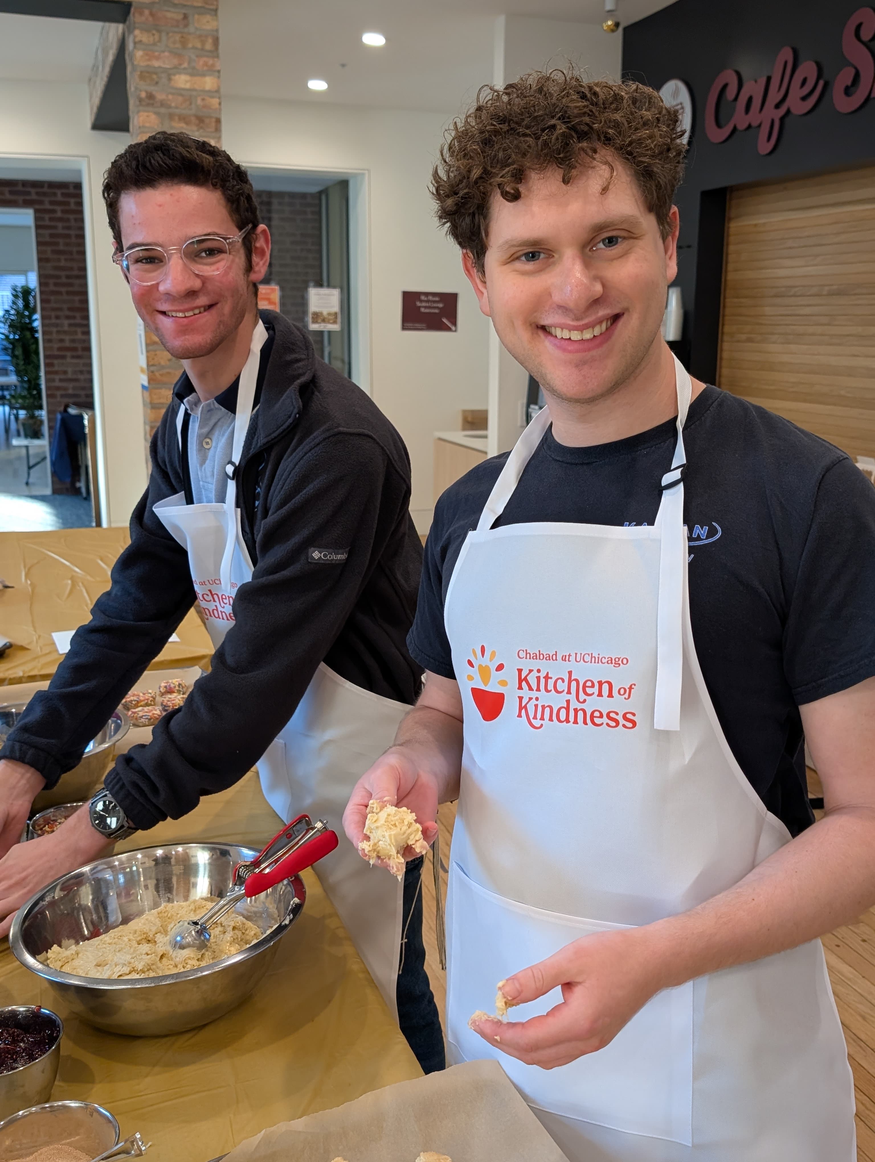 Chabad at UChicago students in Kitchen of Kindness aprons cooking together
