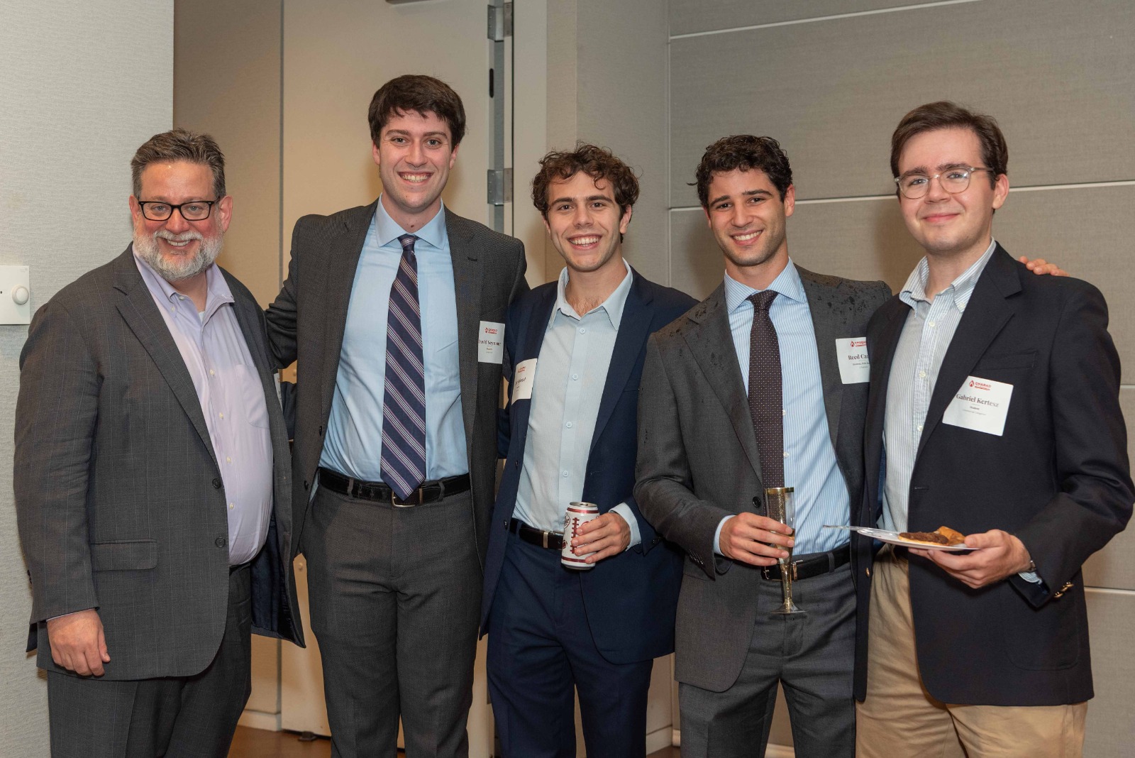 Five guests in suits posing for a photo
