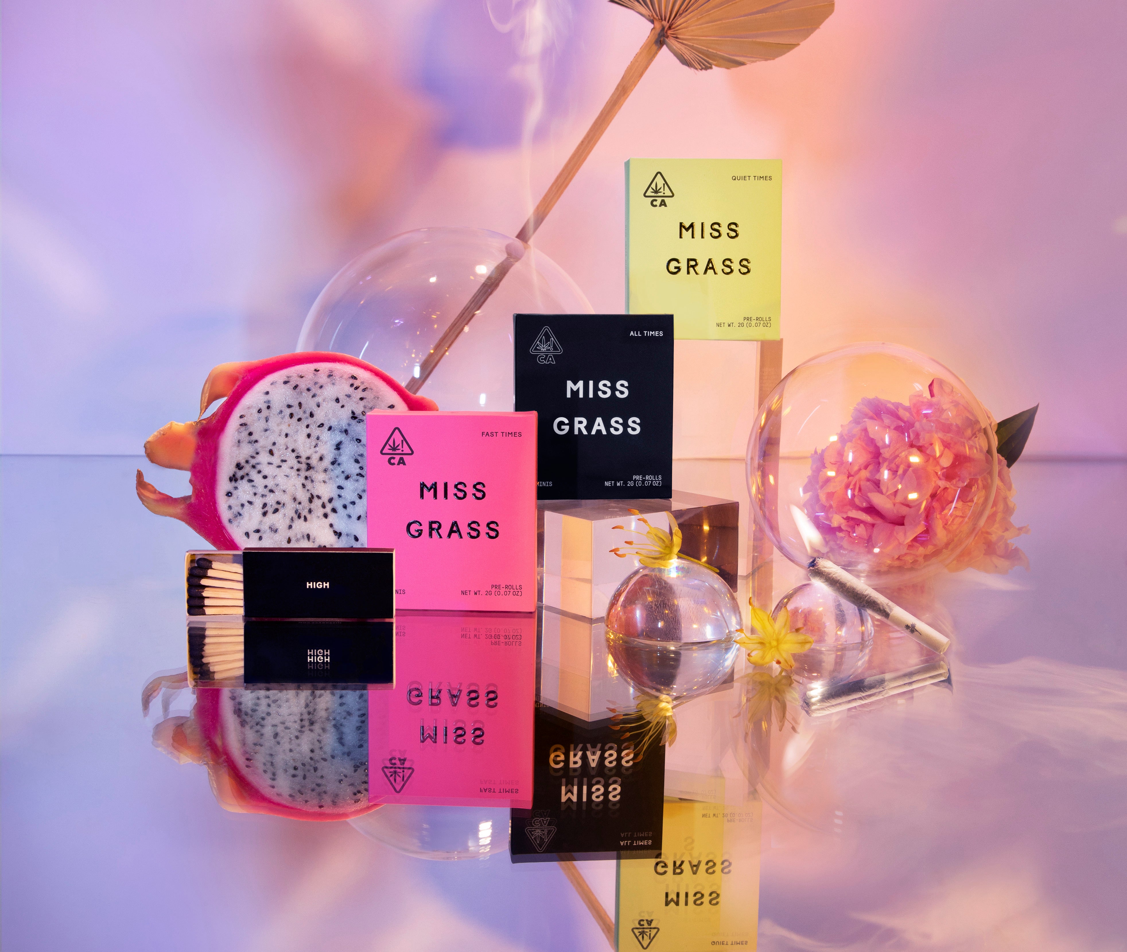 Colorful Miss Grass Minis packages arranged with fruit, flowers and glassware