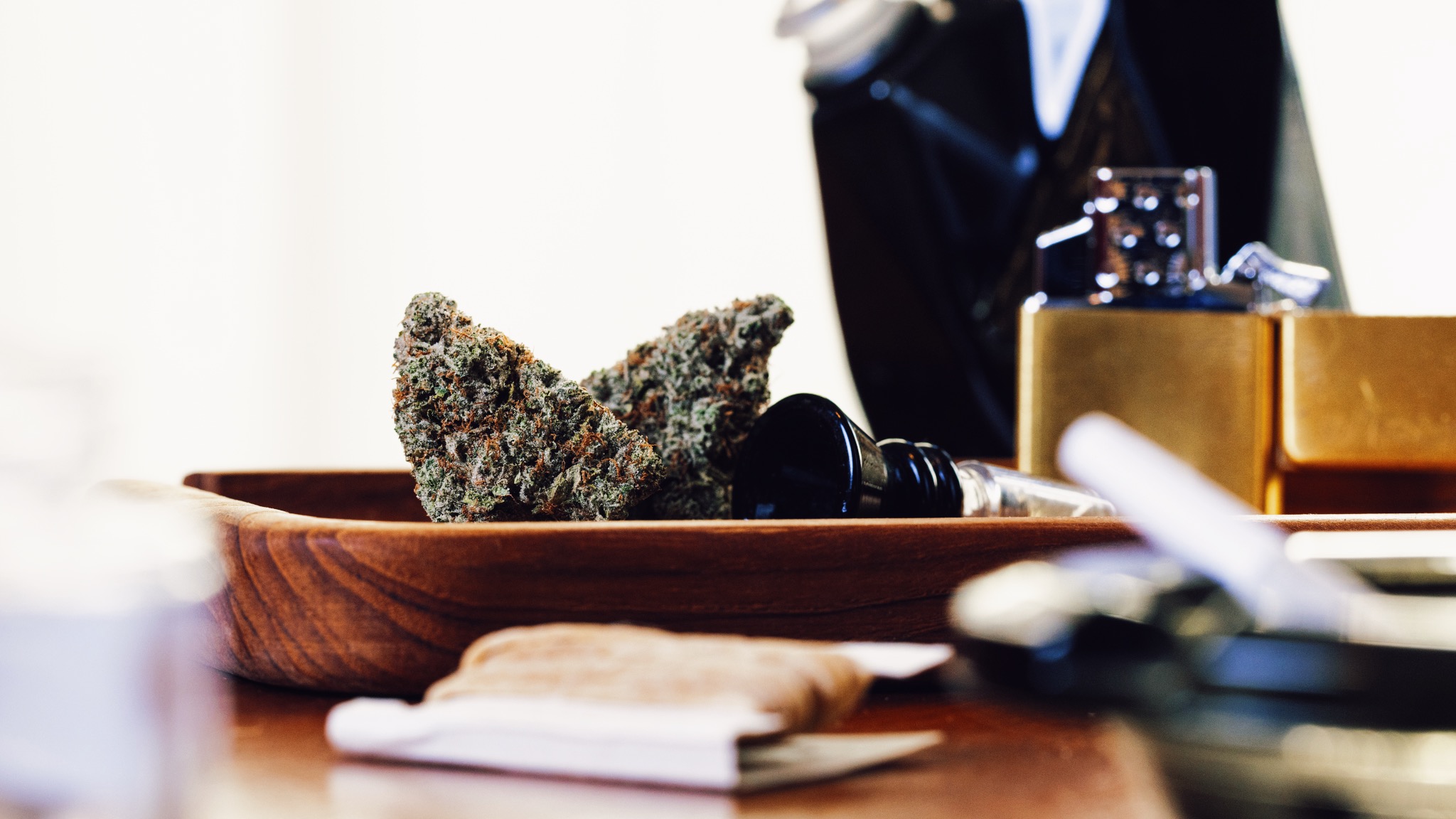 Cannabis flower arranged on a wooden tray with accessories