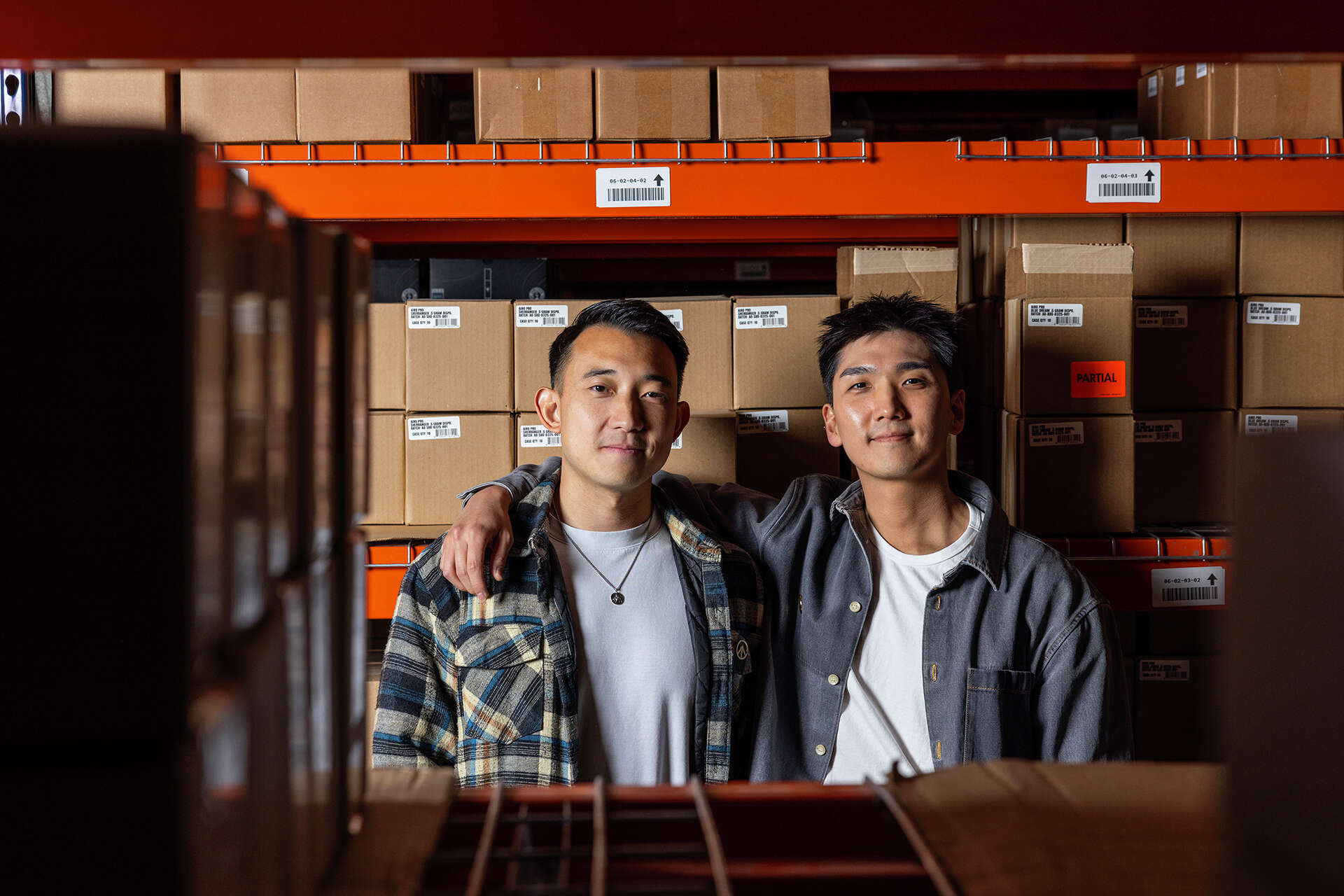 Nabis co-founders Vince Ning, left, and Jun S. Lee standing among warehouse cartons