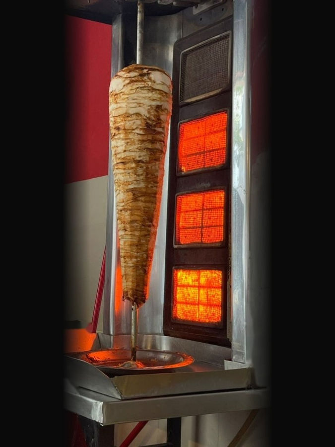Shawarma spit roasting over open flame