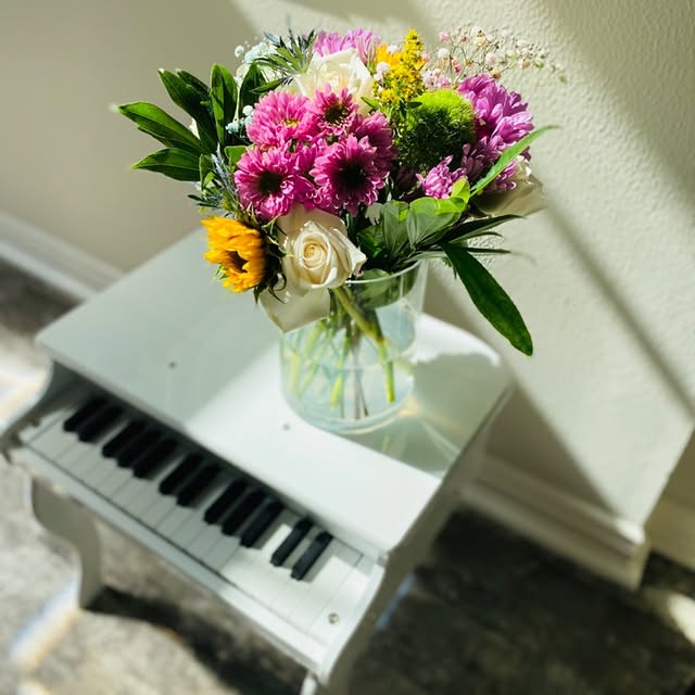 Bouquet coloré chrysanthèmes et roses sur piano