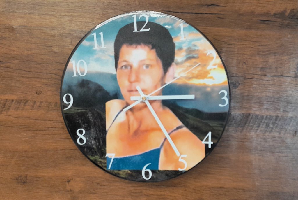 Round wall clock with sunset portrait photo face on wood surface