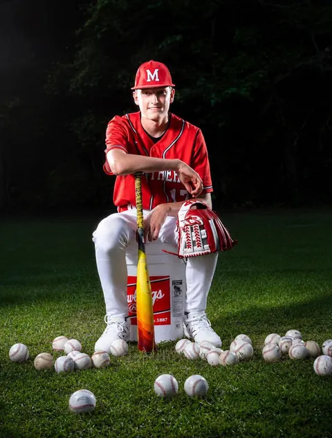Athlete seated on bucket with bats