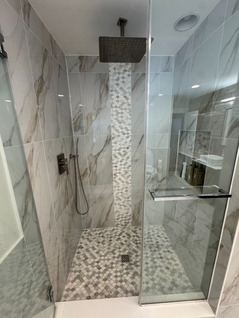 Luxury marble master bathroom with freestanding soaking tub and ceiling rain shower by Remodeling Kings
