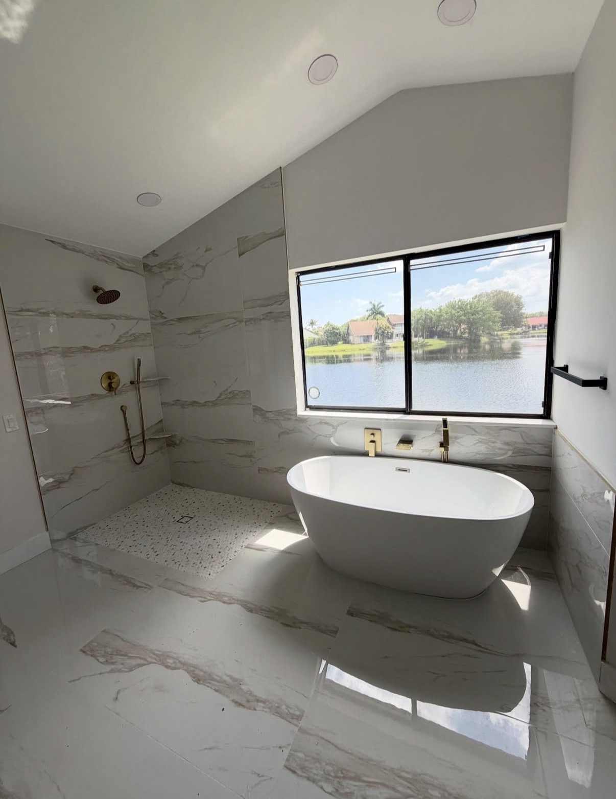 Luxury bathroom remodeling in Hinsdale, IL — walk-in shower with marble-look tile and brushed-gold fixtures