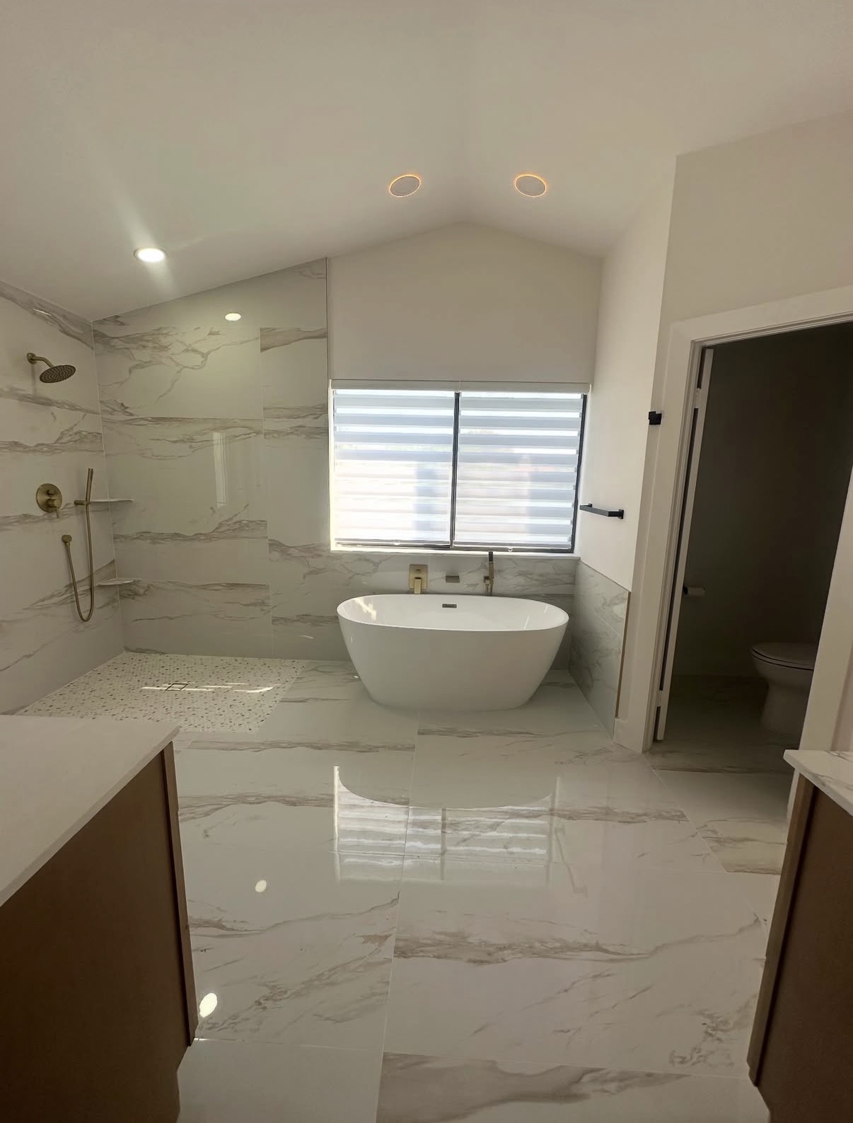 After photo of a luxury bathroom remodeling project in Hinsdale, IL — walk-in shower, freestanding tub, and marble-look tile
