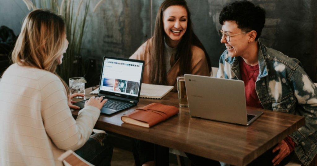 Team working together with laptops and laughing