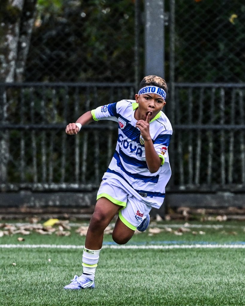 Niño jugador fútbol corre con balón