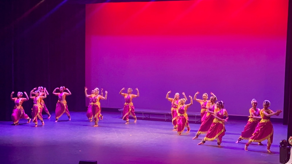 Group performance in green — synchronized and vibrant under stage lights