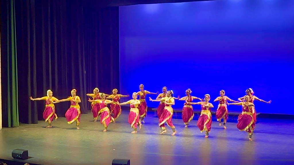 Ensemble performance — dancing in unison with beautiful pink and gold costumes