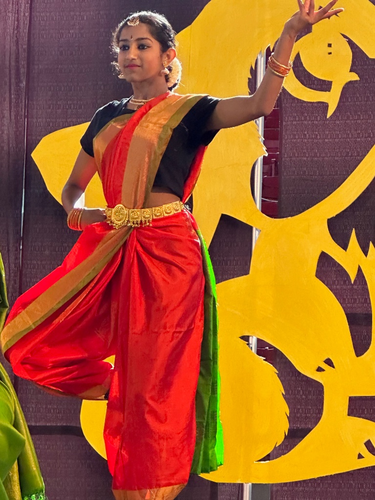 On stage in red — performing with confidence and grace