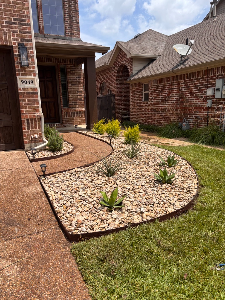 River rock xeriscape bed with agave succulents and metal edging installed in Fort Worth TX