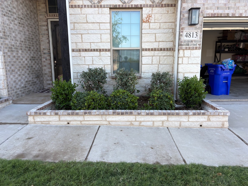 Rectangular masonry stone planter with evergreen shrubs installed in Mansfield TX