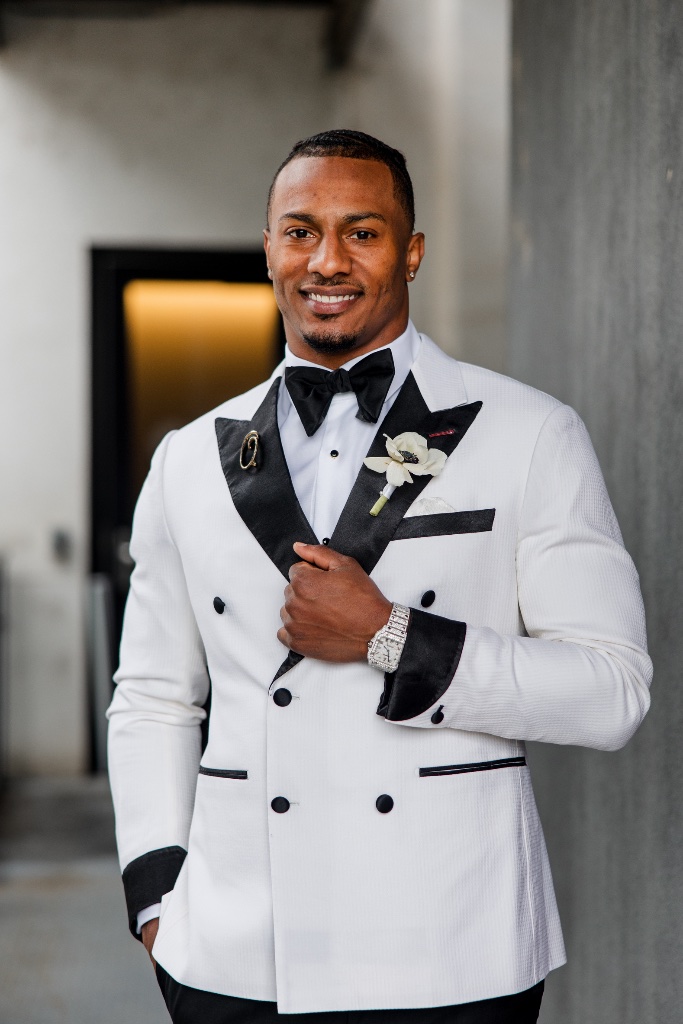 George Odum in white tuxedo smiling
