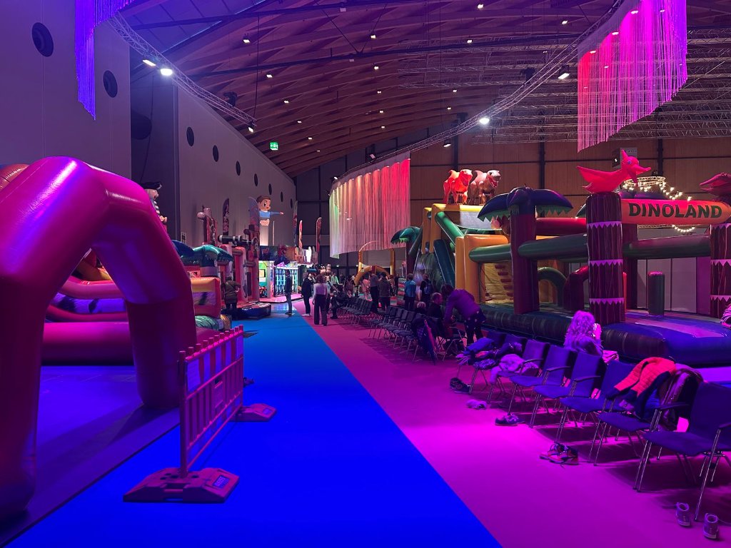 Happy Fun World – Dinoland Hüpfburg mit bunter Beleuchtung am Abend