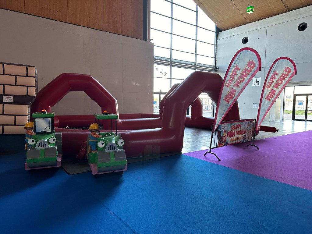 Happy Fun World – Eingangsbereich mit Traktor-Karussell und Bannern