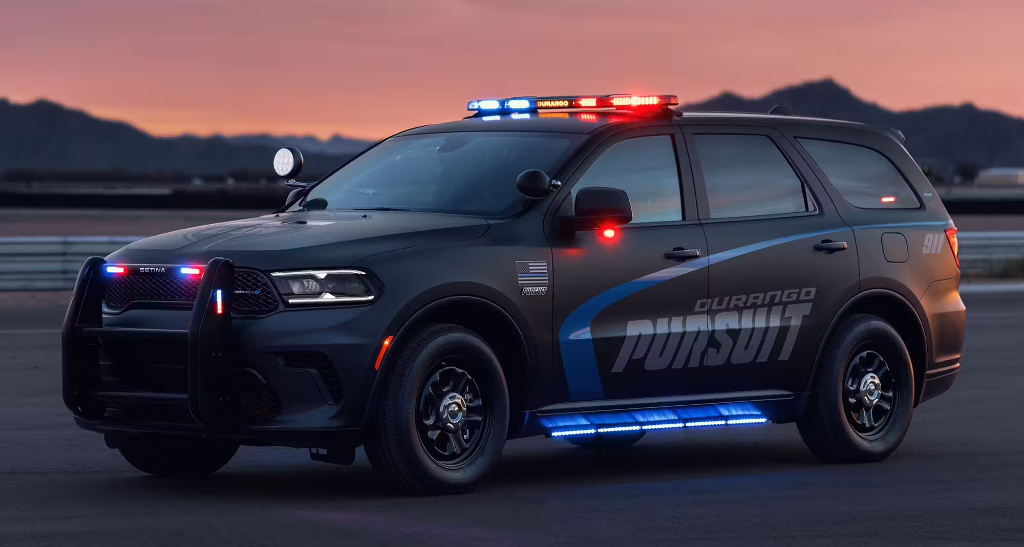 A modern pursuit-rated police SUV with full emergency lighting at dusk