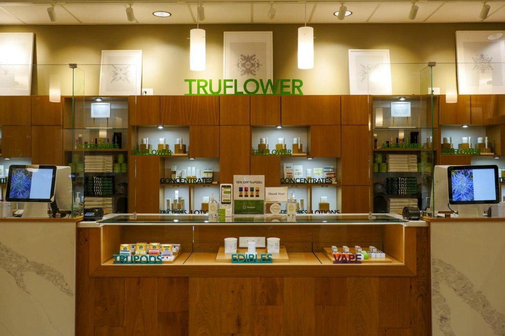 Trulieve retail display counter featuring TruFlower, TruPods, edibles, concentrates and vape products under green signage.