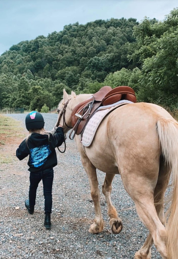 Child leading palomino horse