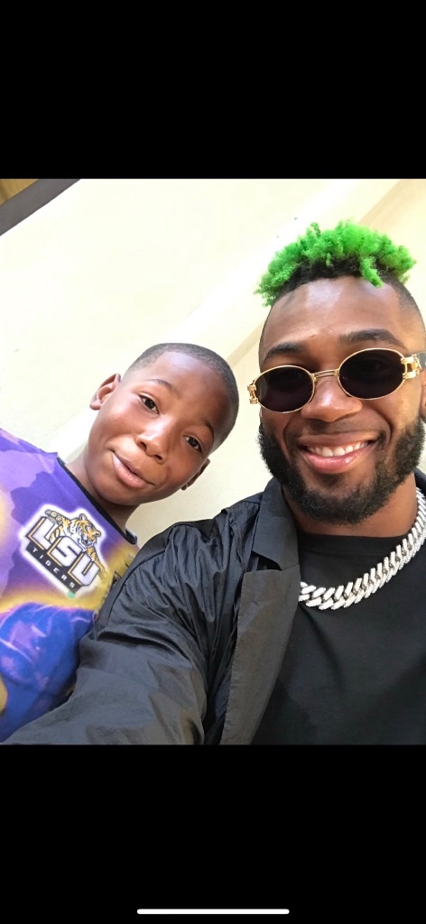 Young Karmelo Anthony in LSU Tigers shirt, smiling in selfie