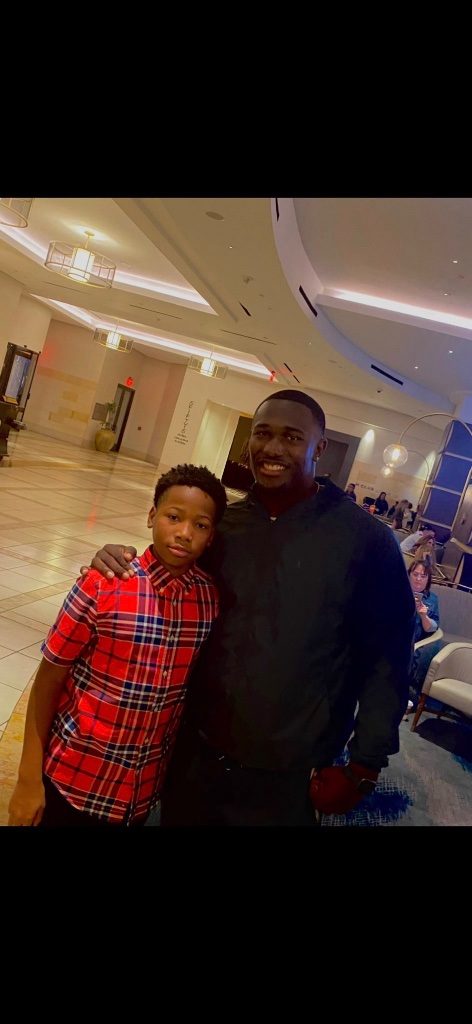 Young Karmelo Anthony in red plaid shirt at hotel lobby