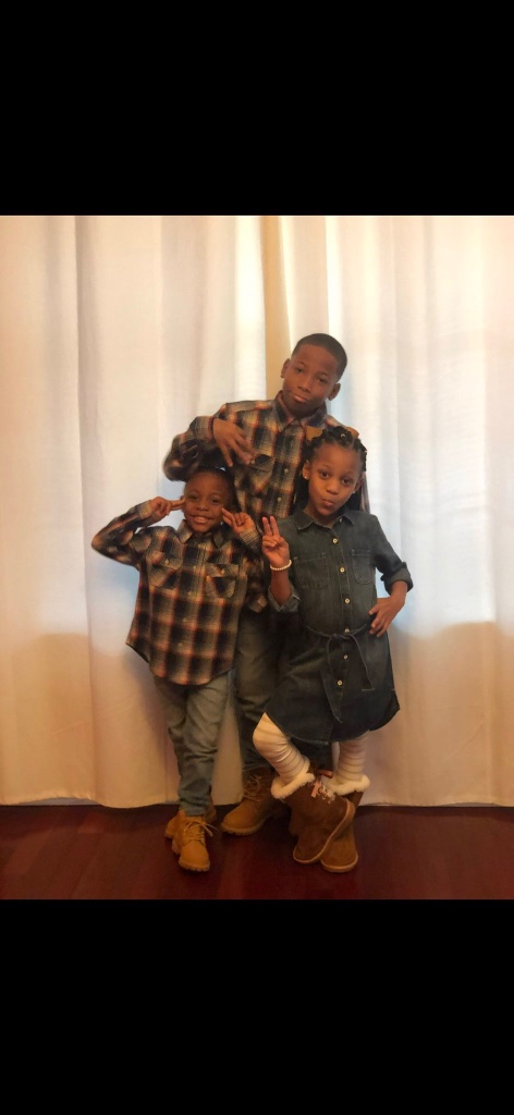 Karmelo Anthony as a child with younger siblings, wearing plaid shirts