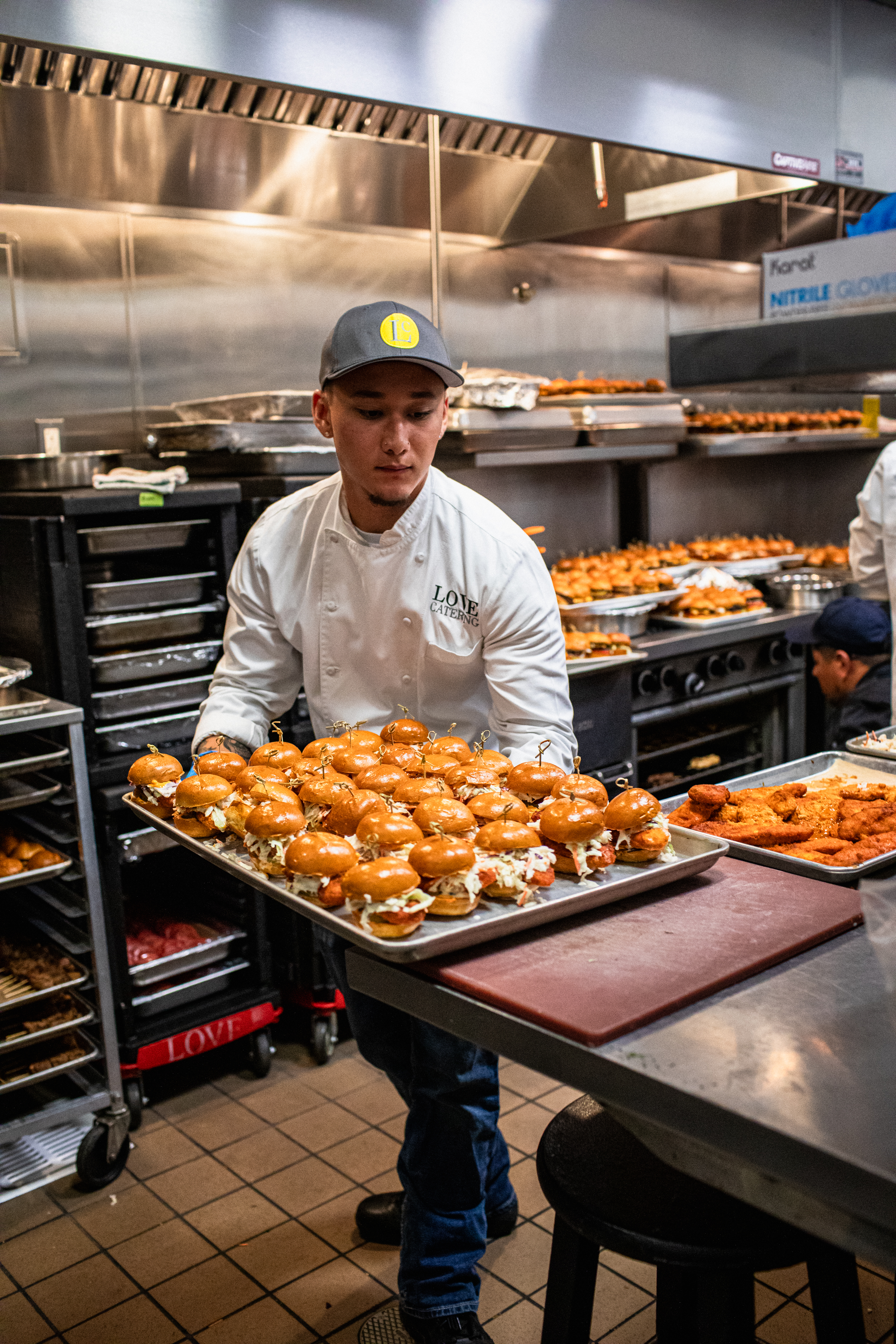 Love Catering chef carrying a tray of sliders through the kitchen at the Minions & Monsters movie premiere