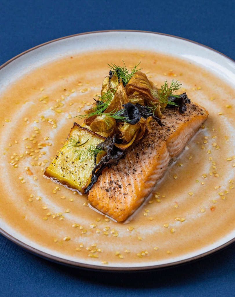 Beautifully plated salmon with seasonal vegetables prepared by Love Catering