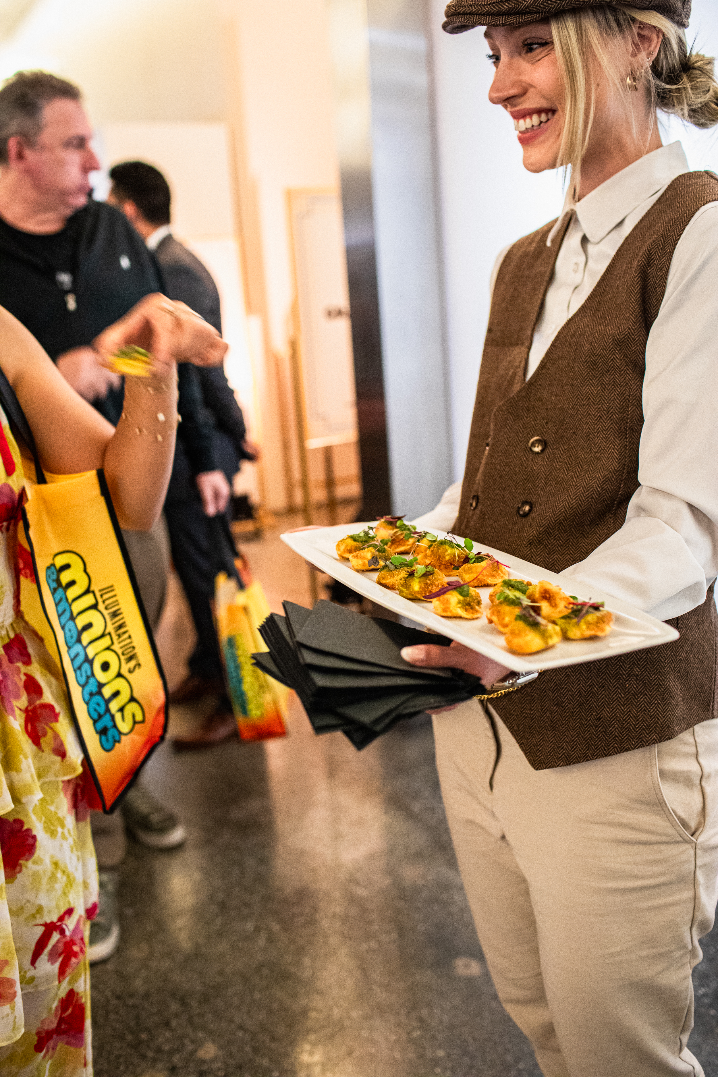 Love Catering server passing hors d'oeuvres to a guest at the Minions & Monsters movie premiere at Milk Studios