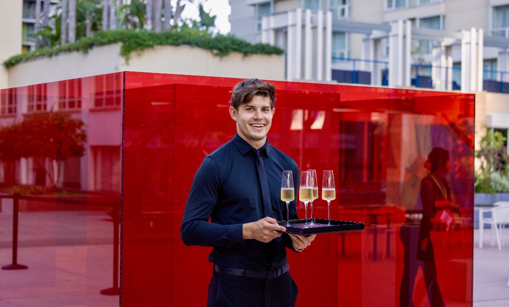 Love Catering server presenting champagne flutes
