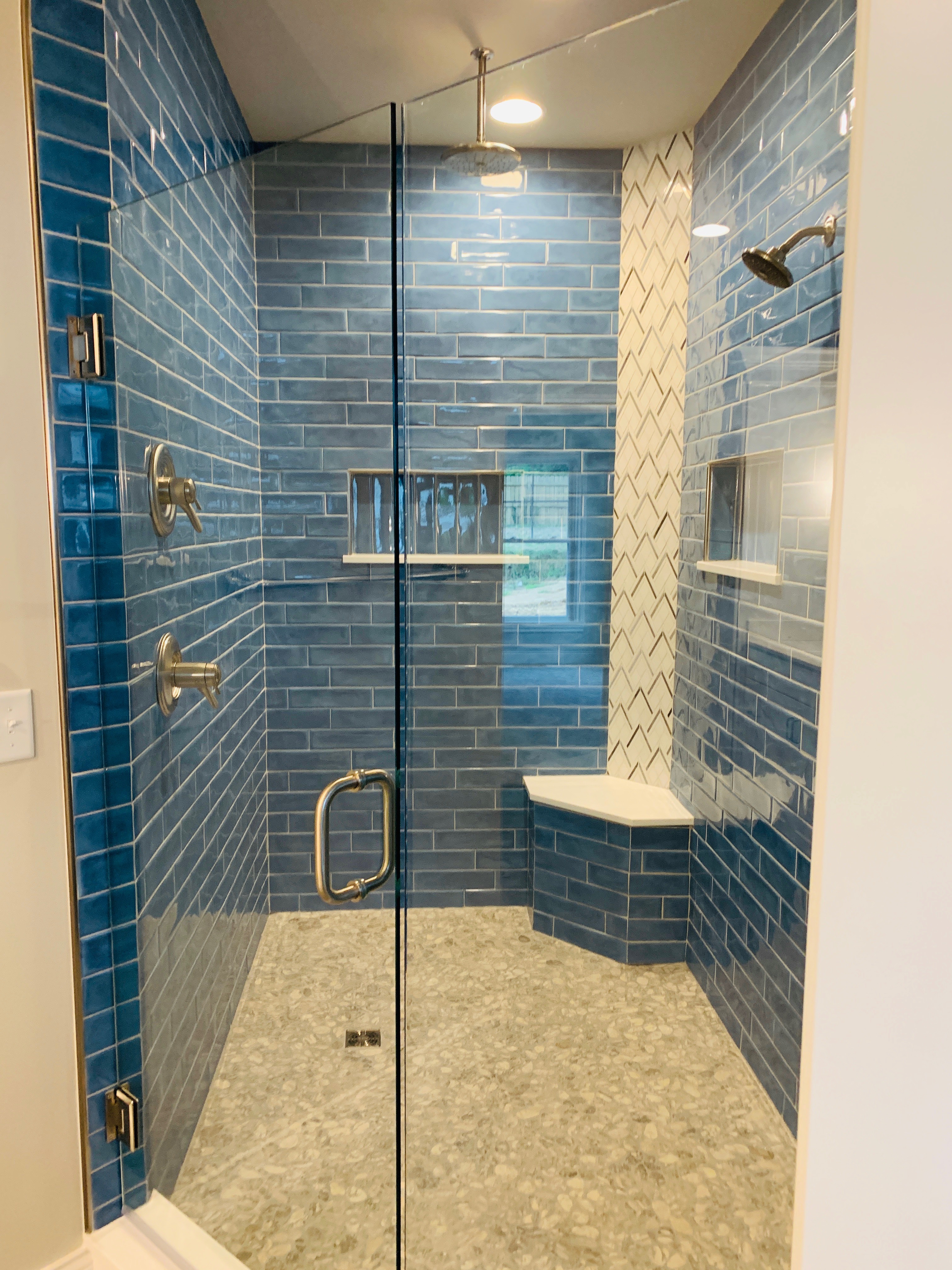 Blue tiled walk-in shower with bench