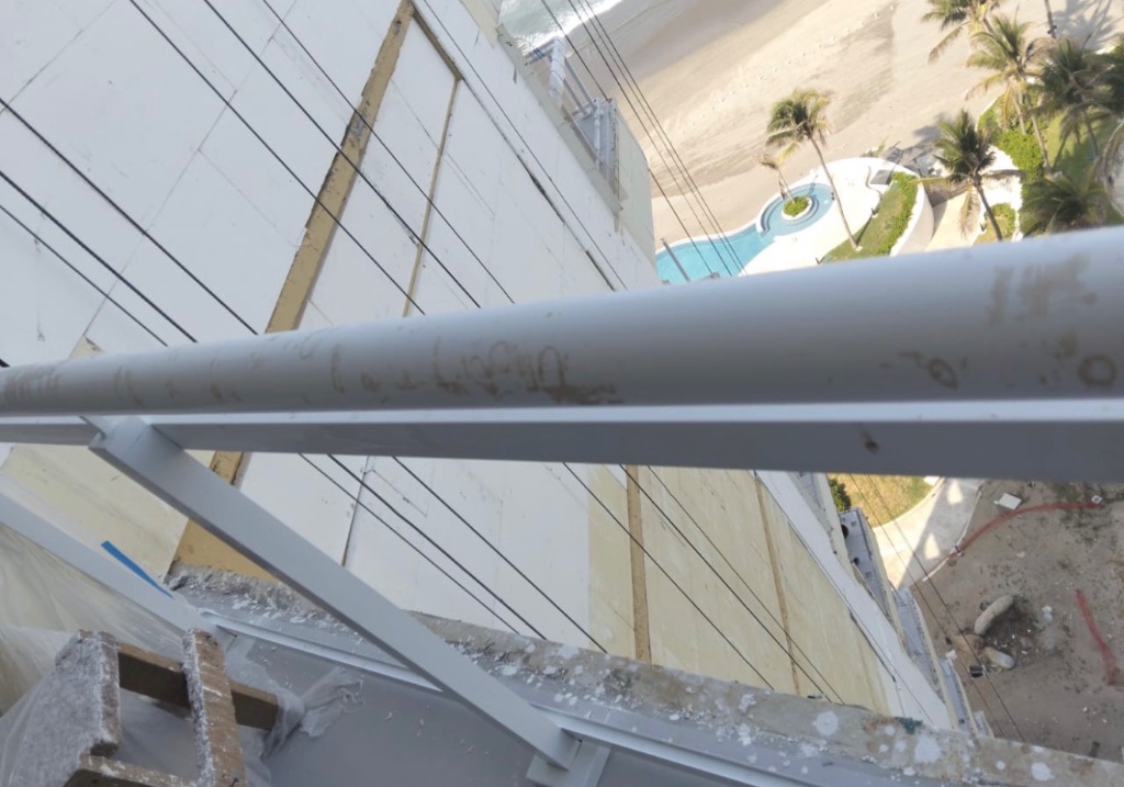 Residuos de construcción sobre barandal y perfil tubular