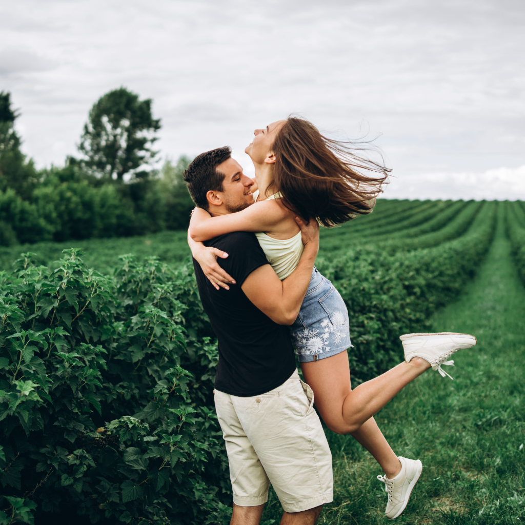 A couple embracing joyfully in a field
