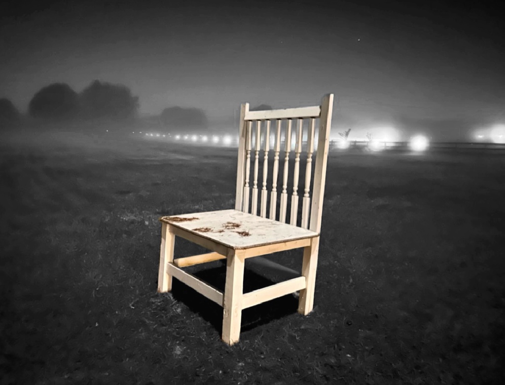 The Lone Chair — a restored painted spindle-back chair photographed alone in a foggy field at night