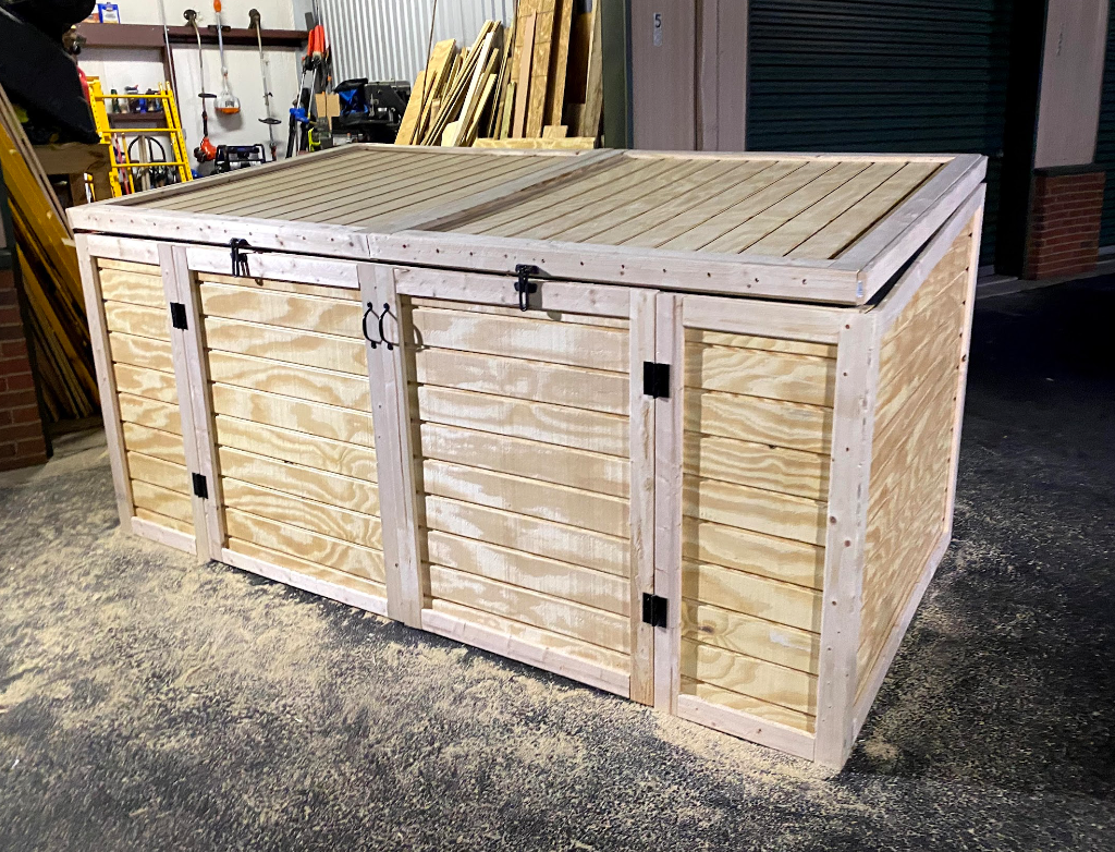 Trash Can Enclosure — a lift-top slatted enclosure built to hide and secure farm trash cans
