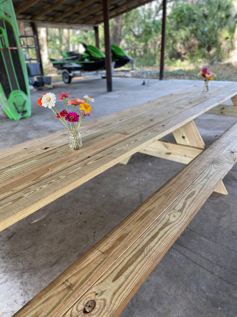 Farm Picnic Table — a long plank-seated picnic table for family gatherings under the pavilion