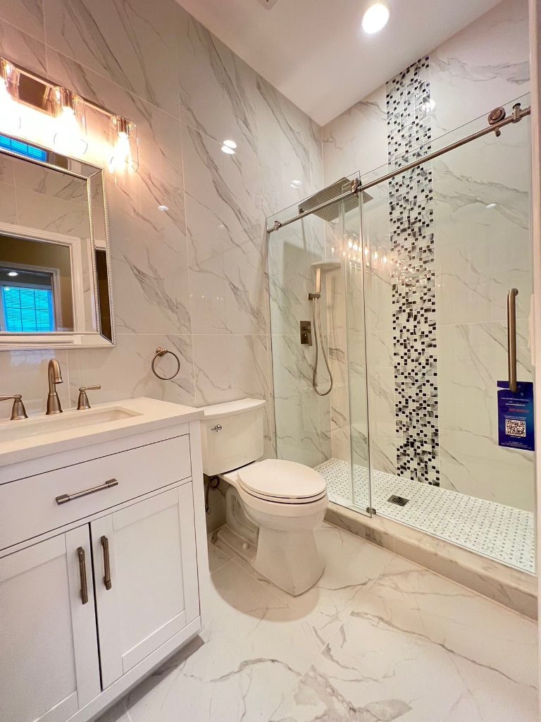 Full bathroom with Calacatta marble tile and glass shower